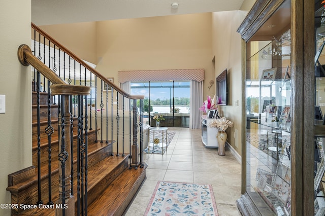 7873 Desmond Ave, Melbourne, FL 32940 - entryway featuring stairs, light tile patterned floors, and a high ceiling