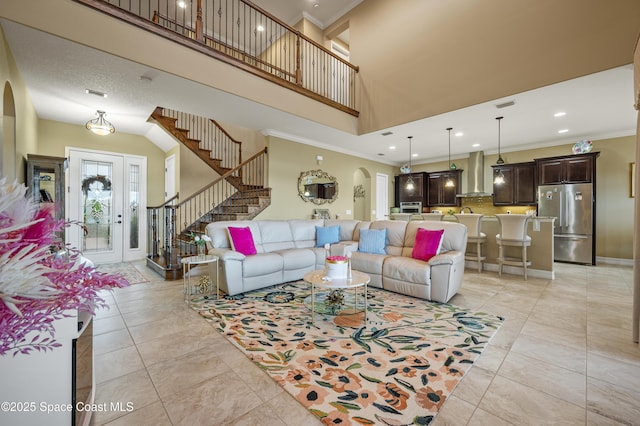 7873 Desmond Ave, Melbourne, FL 32940 - living room with arched walkways, crown molding, stairs, a towering ceiling, and recessed lighting