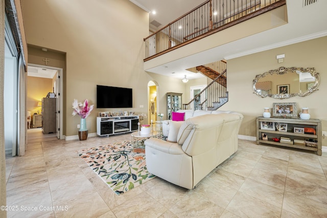 7873 Desmond Ave, Melbourne, FL 32940 - living room with arched walkways, a high ceiling, ornamental molding, and stairway