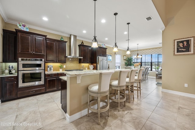 7873 Desmond Ave, Melbourne, FL 32940 - kitchen with wall chimney range hood, appliances with stainless steel finishes, a breakfast bar, tasteful backsplash, and a center island with sink