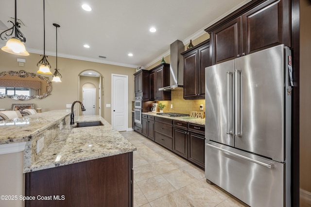 7873 Desmond Ave, Melbourne, FL 32940 - kitchen with appliances with stainless steel finishes, wall chimney range hood, arched walkways, ornamental molding, and dark brown cabinetry