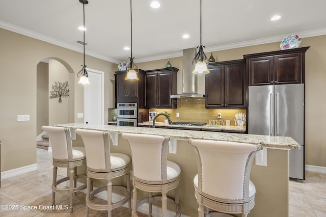 7873 Desmond Ave, Melbourne, FL 32940 - kitchen featuring appliances with stainless steel finishes, wall chimney exhaust hood, a center island with sink, a breakfast bar, and recessed lighting