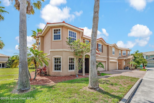 1375 Isabella Dr Unit 108, Melbourne, FL 32935 - view of front of house featuring driveway, a garage, a tile roof, stucco siding, and a front lawn