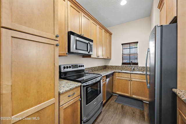1375 Isabella Dr Unit 108, Melbourne, FL 32935 - kitchen with stainless steel appliances, dark wood-type flooring, light stone countertops, a textured ceiling, and light brown cabinets