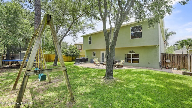 4060 Aria Dr, Melbourne, FL 32904 - rear view of house featuring a trampoline, a fenced backyard, a patio area, a playground, and an outdoor hangout area