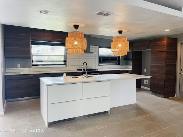 235 NE 2nd St, Satellite Beach, FL 32937 - kitchen with modern cabinets, light countertops, a kitchen island with sink, pendant lighting, and light tile patterned floors