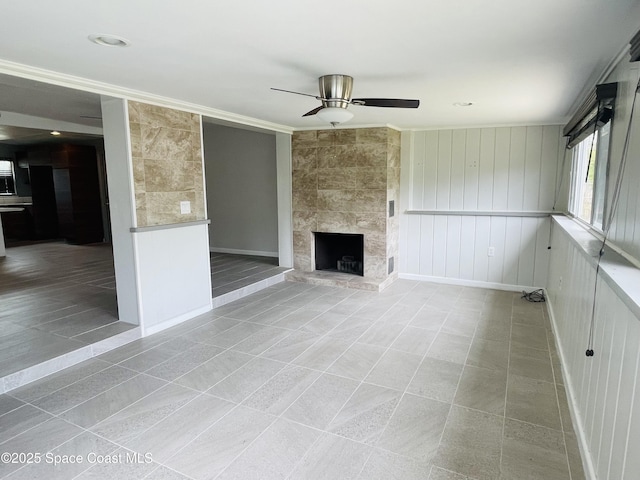 235 NE 2nd St, Satellite Beach, FL 32937 - unfurnished living room with ceiling fan, tile patterned floors, a large fireplace, and crown molding