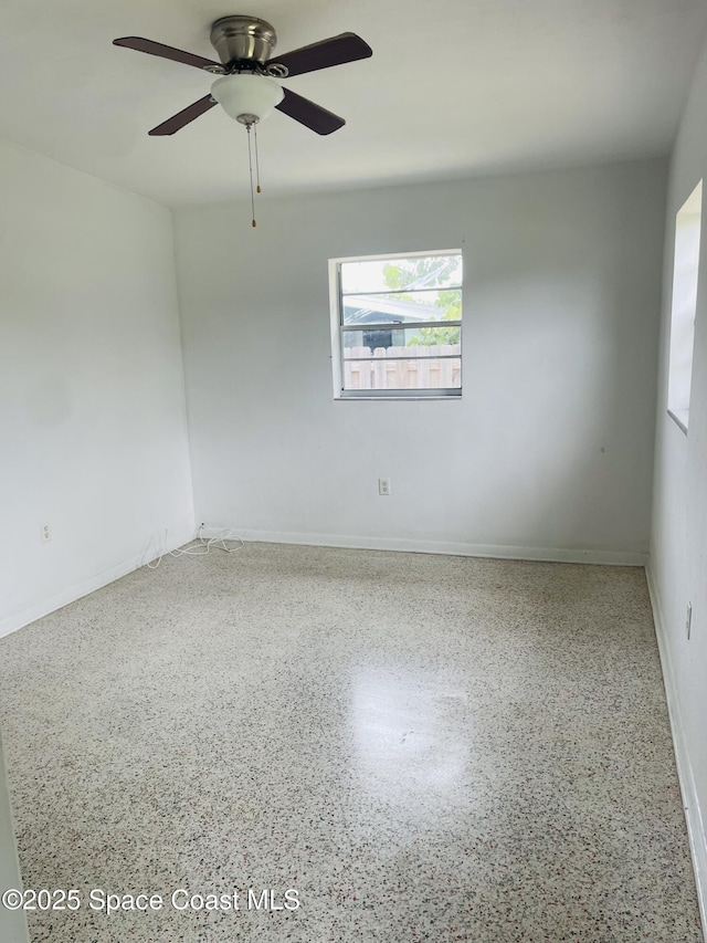 235 NE 2nd St, Satellite Beach, FL 32937 - spare room featuring speckled floor and a ceiling fan
