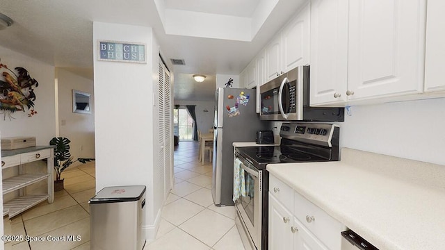 210 Cleveland Ave Unit 210, Cocoa Beach, FL 32931 - kitchen with stainless steel appliances, light tile patterned flooring, white cabinets, and light countertops