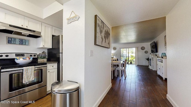 212 Cleveland Ave Unit 212, Cocoa Beach, FL 32931 - kitchen with stainless steel appliances, under cabinet range hood, white cabinetry, dark wood-style flooring, and a textured ceiling