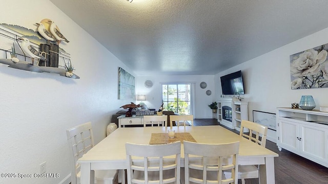 212 Cleveland Ave Unit 212, Cocoa Beach, FL 32931 - dining room featuring dark wood-style flooring, a glass covered fireplace, and a textured ceiling