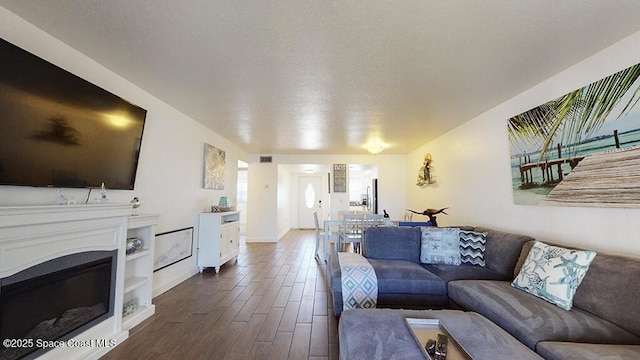 212 Cleveland Ave Unit 212, Cocoa Beach, FL 32931 - living room with dark wood-style floors, a glass covered fireplace, and a textured ceiling