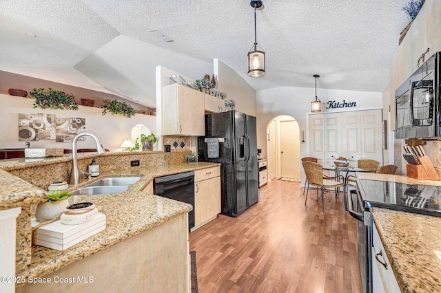 1137 White Oak Cir, Melbourne, FL 32934 - kitchen featuring lofted ceiling, arched walkways, black appliances, light brown cabinetry, and light wood-type flooring