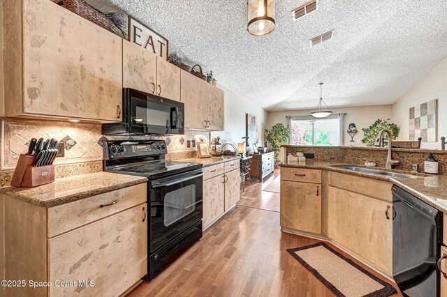 1137 White Oak Cir, Melbourne, FL 32934 - kitchen featuring black appliances, light brown cabinets, light wood-style flooring, a textured ceiling, and tasteful backsplash