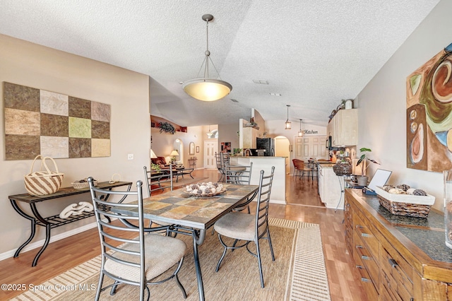 1137 White Oak Cir, Melbourne, FL 32934 - dining room featuring a textured ceiling, light wood finished floors, and lofted ceiling
