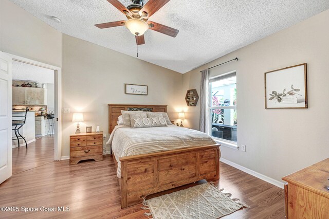 1137 White Oak Cir, Melbourne, FL 32934 - bedroom featuring lofted ceiling, a textured ceiling, wood finished floors, and ceiling fan