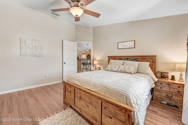 1137 White Oak Cir, Melbourne, FL 32934 - bedroom featuring light wood finished floors, a textured ceiling, and ceiling fan