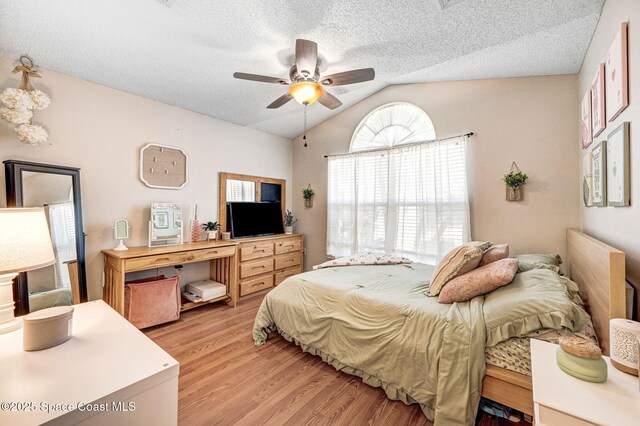 1137 White Oak Cir, Melbourne, FL 32934 - bedroom featuring light wood-style flooring, lofted ceiling, a textured ceiling, and ceiling fan