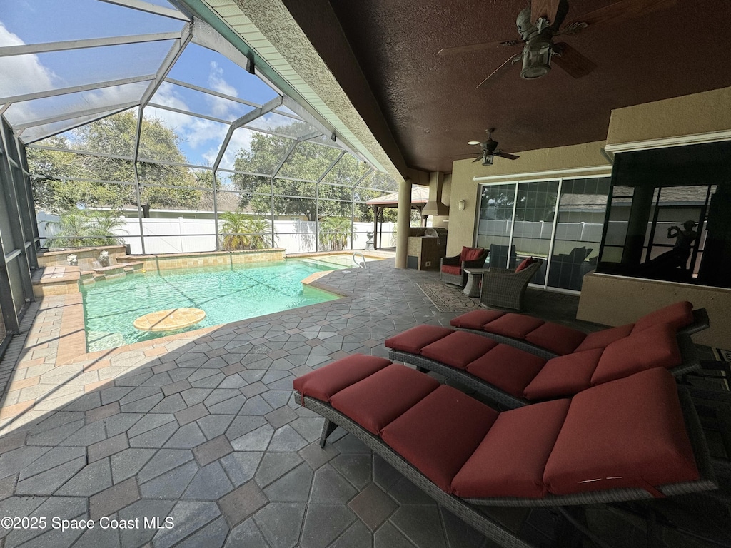 1351 Tamango Dr, Melbourne, FL 32904 - view of swimming pool featuring a patio, ceiling fan, a fenced backyard, and glass enclosure