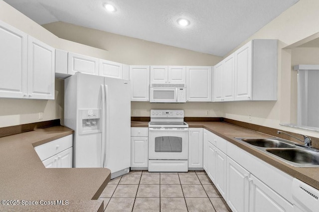 461 Coply Ter, Sebastian, FL 32958 - kitchen with white appliances, lofted ceiling, white cabinets, a textured ceiling, and light tile patterned flooring