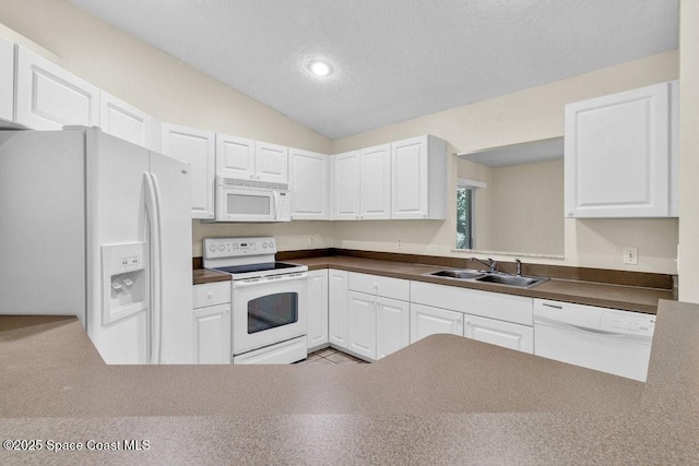 461 Coply Ter, Sebastian, FL 32958 - kitchen with white appliances, dark countertops, vaulted ceiling, white cabinetry, and a textured ceiling