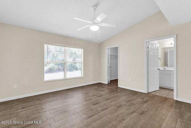 461 Coply Ter, Sebastian, FL 32958 - unfurnished bedroom featuring lofted ceiling, wood finished floors, a walk in closet, a textured ceiling, and a closet