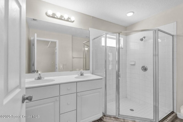461 Coply Ter, Sebastian, FL 32958 - bathroom featuring double vanity, a textured ceiling, and a shower stall