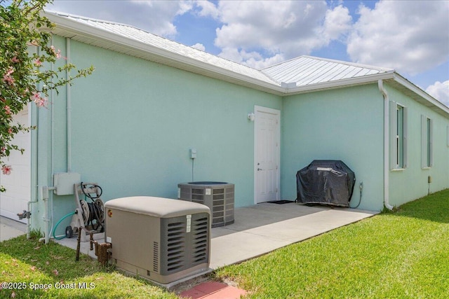 608 Lorelei Ave, Melbourne, FL 32901 - view of property exterior with a metal roof, a yard, and stucco siding