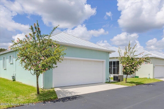 608 Lorelei Ave, Melbourne, FL 32901 - view of front of house featuring stucco siding, driveway, an attached garage, and a metal roof