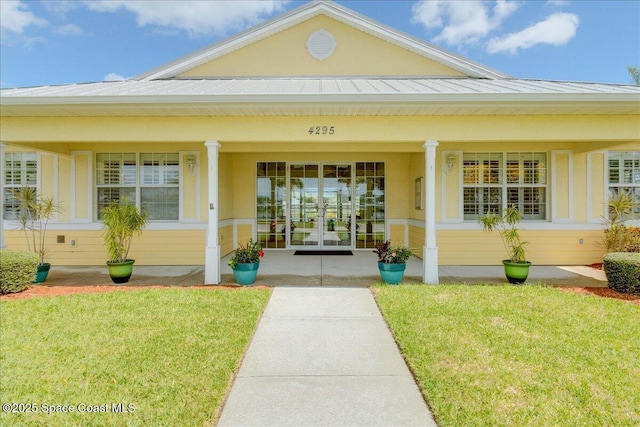 608 Lorelei Ave, Melbourne, FL 32901 - view of exterior entry featuring french doors, a lawn, and a porch