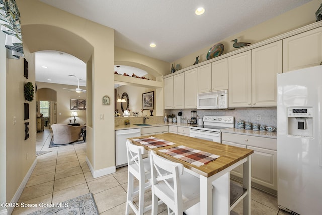 784 Bayside Dr Unit 501, Cape Canaveral, FL 32920 - kitchen with white appliances, arched walkways, ceiling fan, light tile patterned flooring, and backsplash