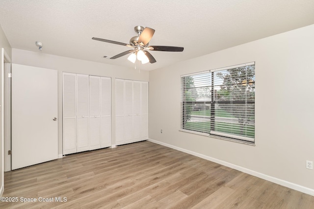 1337 Pakenham St NW, Palm Bay, FL 32907 - unfurnished bedroom featuring multiple closets, light wood-style floors, and a ceiling fan