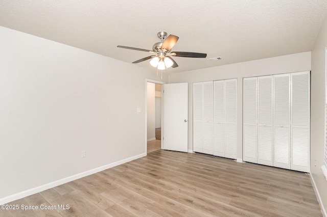 1337 Pakenham St NW, Palm Bay, FL 32907 - unfurnished bedroom with two closets, light wood finished floors, and ceiling fan