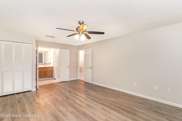 1337 Pakenham St NW, Palm Bay, FL 32907 - unfurnished bedroom with light wood-style floors, ensuite bath, and a ceiling fan
