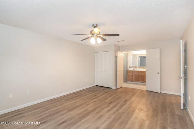 1337 Pakenham St NW, Palm Bay, FL 32907 - unfurnished bedroom featuring light wood-style floors, ensuite bathroom, a closet, and a ceiling fan