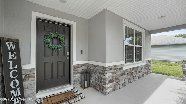 6830 Harp Ave, Cocoa, FL 32927 - property entrance featuring a porch, stone siding, and stucco siding