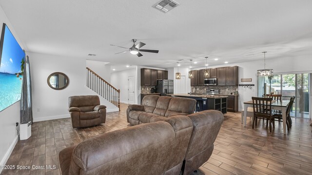 6830 Harp Ave, Cocoa, FL 32927 - living area featuring dark wood finished floors, a ceiling fan, stairs, and recessed lighting