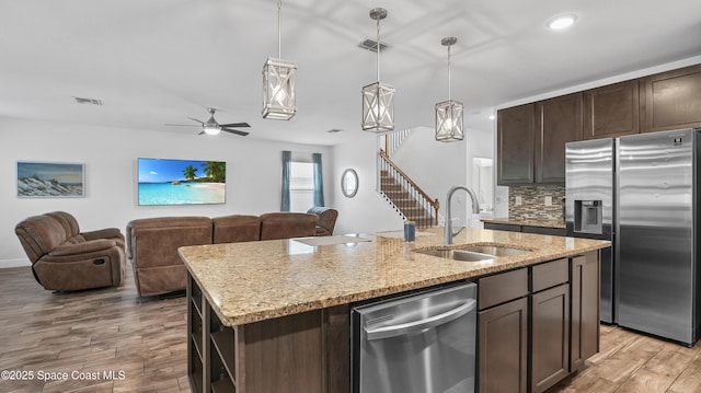 6830 Harp Ave, Cocoa, FL 32927 - kitchen featuring appliances with stainless steel finishes, light wood-type flooring, dark brown cabinetry, open floor plan, and recessed lighting