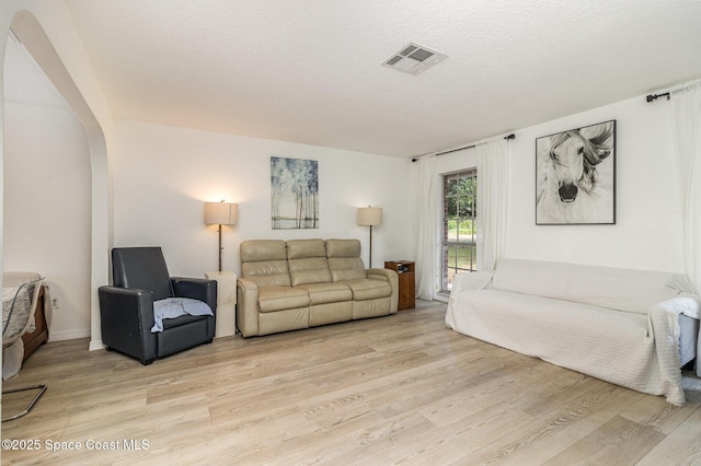 4685 Sand Point Rd, Grant, FL 32949 - living room with light wood-style floors, arched walkways, and a textured ceiling