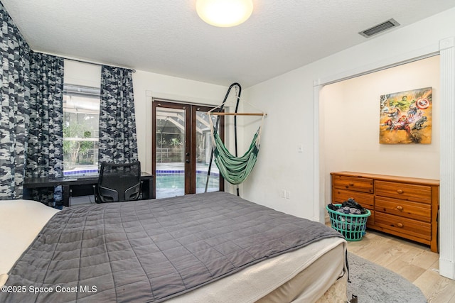 4685 Sand Point Rd, Grant, FL 32949 - bedroom with access to exterior, wood finished floors, and a textured ceiling