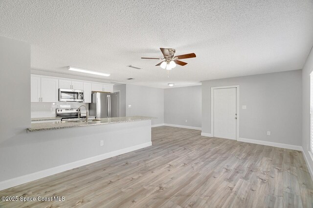 1256 16th Ave SW, Vero Beach, FL 32962 - unfurnished living room with a ceiling fan, light wood-style flooring, and a textured ceiling