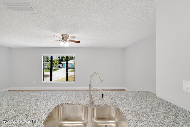 1256 16th Ave SW, Vero Beach, FL 32962 - detailed view of a ceiling fan, a textured ceiling, and light stone counters