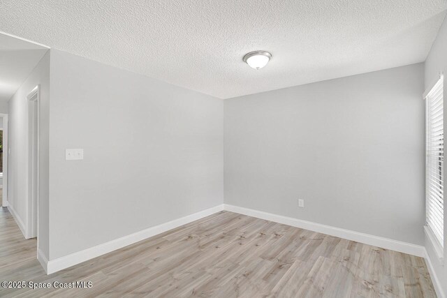 1256 16th Ave SW, Vero Beach, FL 32962 - empty room featuring light wood finished floors, a textured ceiling, and healthy amount of natural light