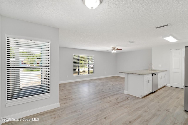 1256 16th Ave SW, Vero Beach, FL 32962 - kitchen featuring a textured ceiling, ceiling fan, stainless steel dishwasher, white cabinets, and light wood finished floors