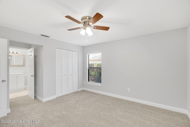 1256 16th Ave SW, Vero Beach, FL 32962 - unfurnished bedroom featuring light carpet, a closet, ceiling fan, and a textured ceiling