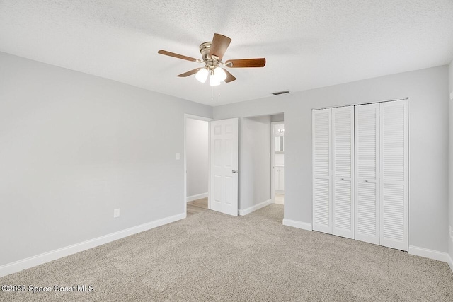 1256 16th Ave SW, Vero Beach, FL 32962 - unfurnished bedroom featuring carpet flooring, a closet, a textured ceiling, and a ceiling fan