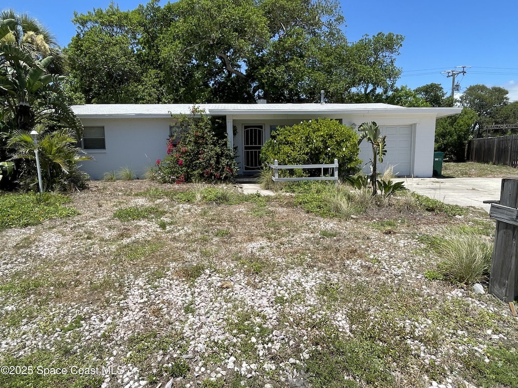 770 2nd Ave, Satellite Beach, FL 32937 - view of front facade with an attached garage, driveway, and stucco siding
