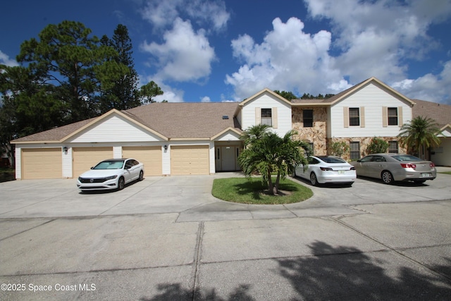 9027 Manchester Ln Unit 22F, West Melbourne, FL 32904 - view of front of home with driveway, an attached garage, and stone siding