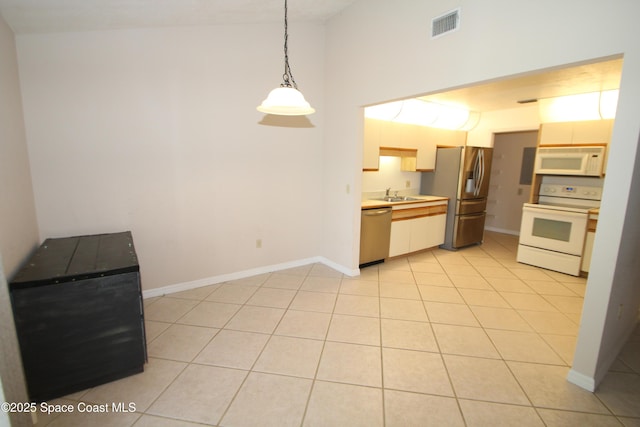 9027 Manchester Ln Unit 22F, West Melbourne, FL 32904 - kitchen featuring appliances with stainless steel finishes, light countertops, hanging light fixtures, and light tile patterned flooring