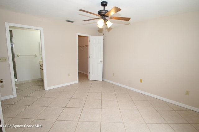 9027 Manchester Ln Unit 22F, West Melbourne, FL 32904 - unfurnished bedroom with a spacious closet, a closet, a ceiling fan, and light tile patterned flooring